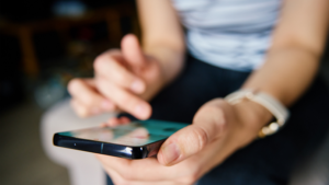 alt=woman-holding-smartphone