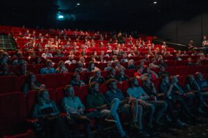 alt=people-sitting-in-auditorium-seats
