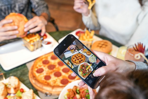 alt=hand-taking-a-photo-of-pizza